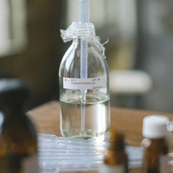 Glass bottles with liquid in a laboratory setting, featuring selective focus and blurred background.